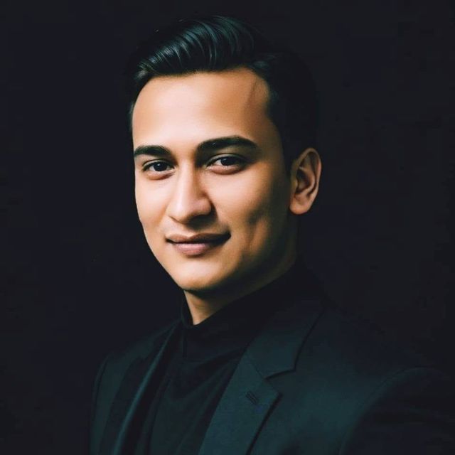 Snehaashish Pathakk, founder of SP Group of Companies, in a navy suit against a dark background